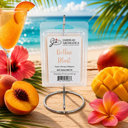 A pack of Jarhead Aromatics Bellini Blast Soy Wax Melts | Tangerine, Peach & Tropical Mango rests on a holder, surrounded by slices of peach and mango, a refreshing drink, and vibrant tropical flowers. Their lively tropical fragrance fills the air as the beach and ocean glisten in the background.