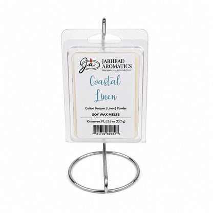A package of Jarhead Aromatics Coastal Linen Soy Wax Melt | Fresh Linen, Ozone & Sandalwood is displayed upright on a silver metal stand against a plain white background, accentuating its blend of fresh linen, ozone, and sandalwood fragrances.