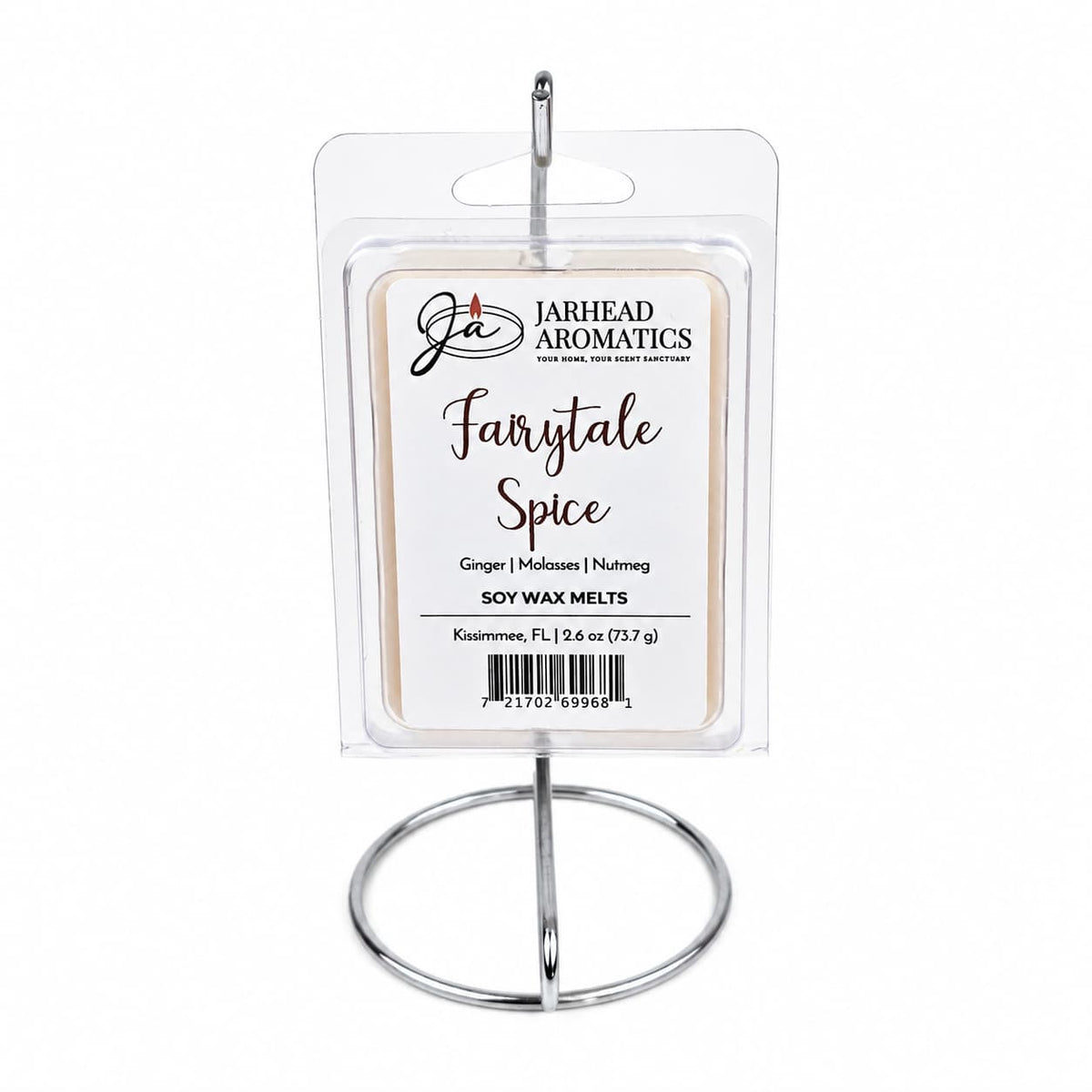 A pack of Jarhead Aromatics Fairytale Spice Soy Wax Melts—highlighting a comforting blend of gingerbread, molasses, and warm spice—is displayed on a silver metal stand. The label showcases enticing notes of ginger, molasses, and nutmeg.