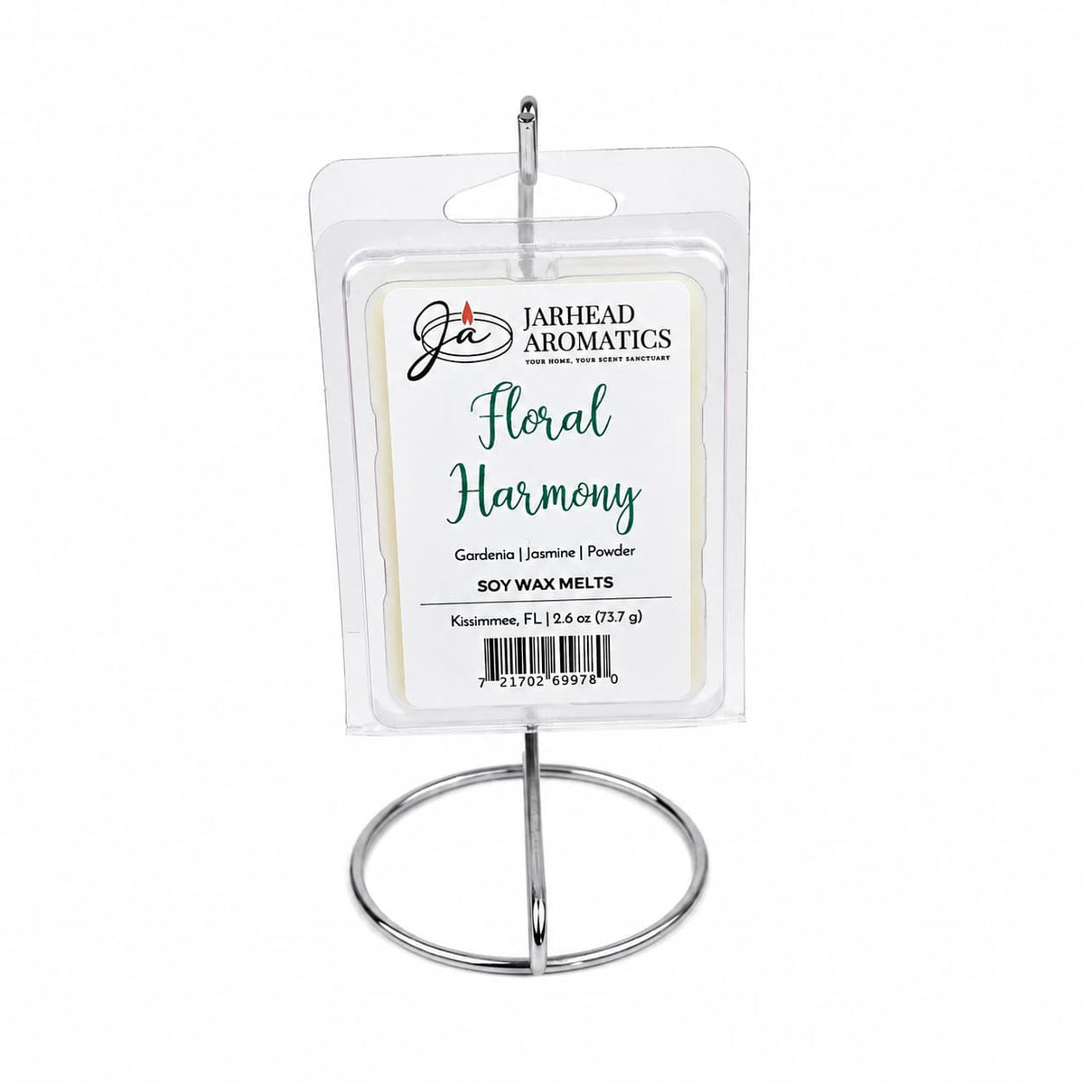 A package of Jarhead Aromatics Floral Harmony Soy Wax Melt | Gardenia, Jasmine & Tuberose is displayed upright on a silver metal stand. The label highlights the blend of gardenia, jasmine, and tuberose fragrances, offering a long-lasting and elegantly floral scent.