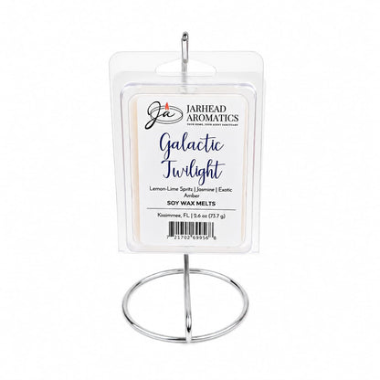 A package of Jarhead Aromatics Galactic Twilight Soy Wax Melt | Bergamot, Amber & Sandalwood is displayed on a silver stand. The label highlights notes of bergamot, amber, and sandalwood, emphasizing this highly fragrant soy wax melt crafted from premium soy wax.