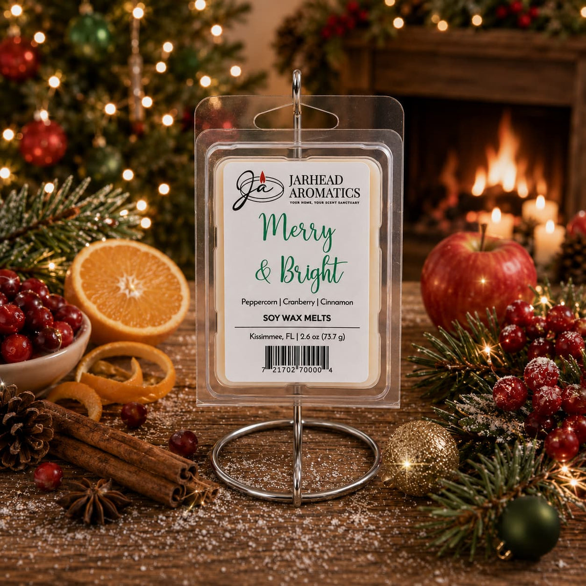 A Jarhead Aromatics Merry & Bright Soy Wax Melt plastic clamshell package sits on a wooden table surrounded by oranges, cranberries, cinnamon sticks, pine branches, and ornaments in front of a fireplace.