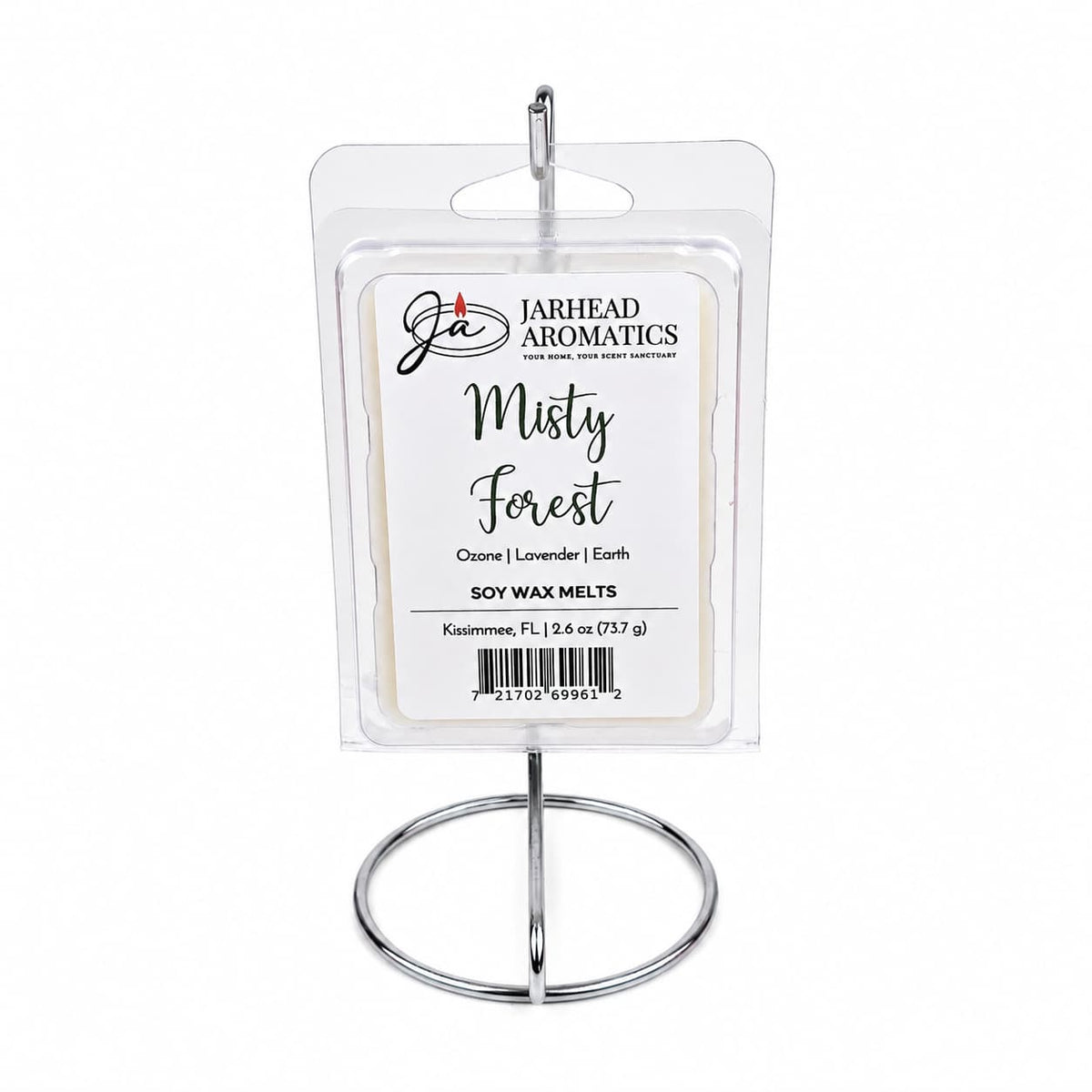 A package of Jarhead Aromatics Misty Forest Soy Wax Melt | Moss, Juniper & Rain-Kissed Woods is displayed upright on a silver metal stand against a white background, perfect for bringing a natural home fragrance into your space.