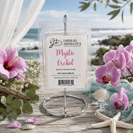 A package of Jarhead Aromatics Mystic Orchid Soy Wax Melt | Orchid, Salt Air & Vanilla rests on a wooden table, encircled by pink orchids and seashells with tranquil beach scenery in the background. The label highlights notes of salt air, orchid, and vanilla—signature coastal home fragrance scents—crafted from premium soy wax for a luxurious aromatic experience.