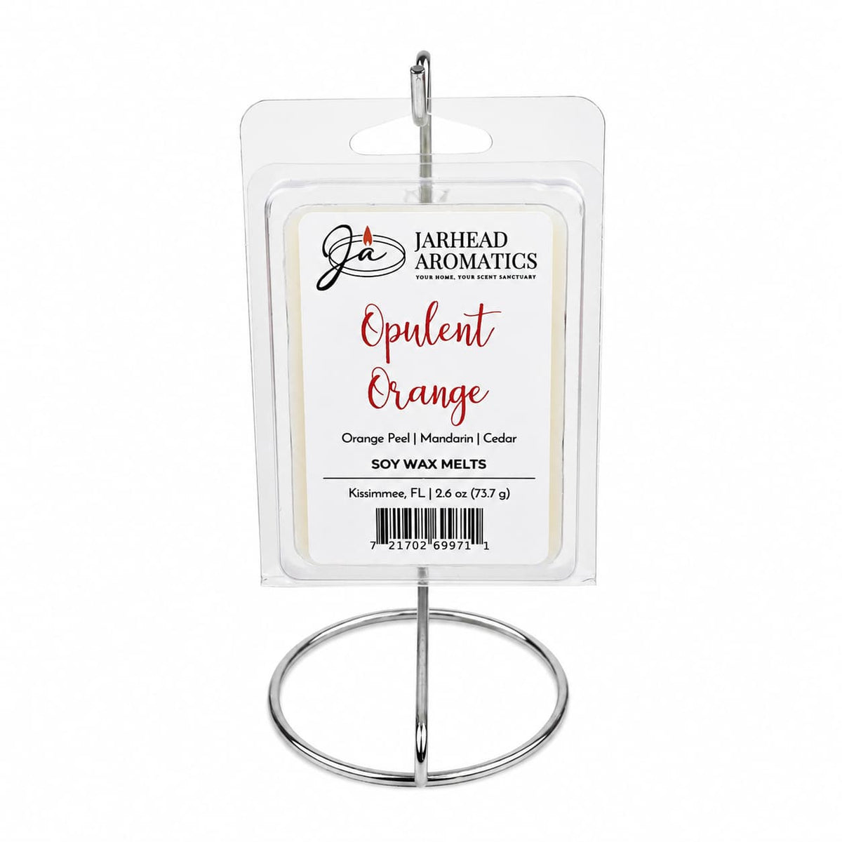 A clear, rectangular package of Jarhead Aromatics’ Opulent Orange Soy Wax Melt—infused with orange, grapefruit, and lemon—is showcased on a silver metal stand. The label highlights bright citrus fragrance notes and features the premium soy wax formula.