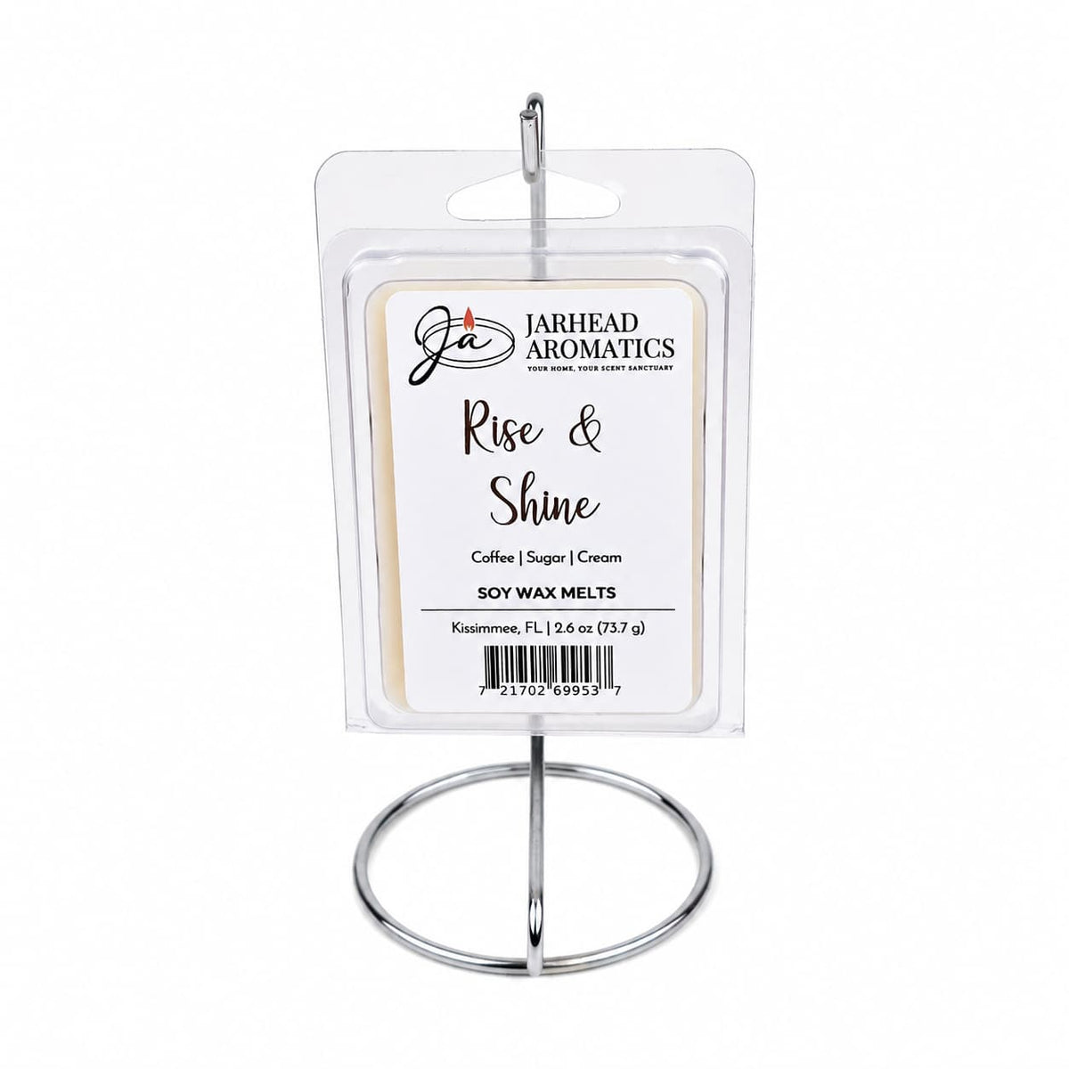 A hand-poured package of Jarhead Aromatics Rise & Shine Soy Wax Melt | Fresh Coffee, Sugar & Cream rests on a metal stand. The label showcases its inviting blend of fresh coffee, sugar, and cream fragrances. Each package contains 2.6 oz (73 g) of aromatic delight.