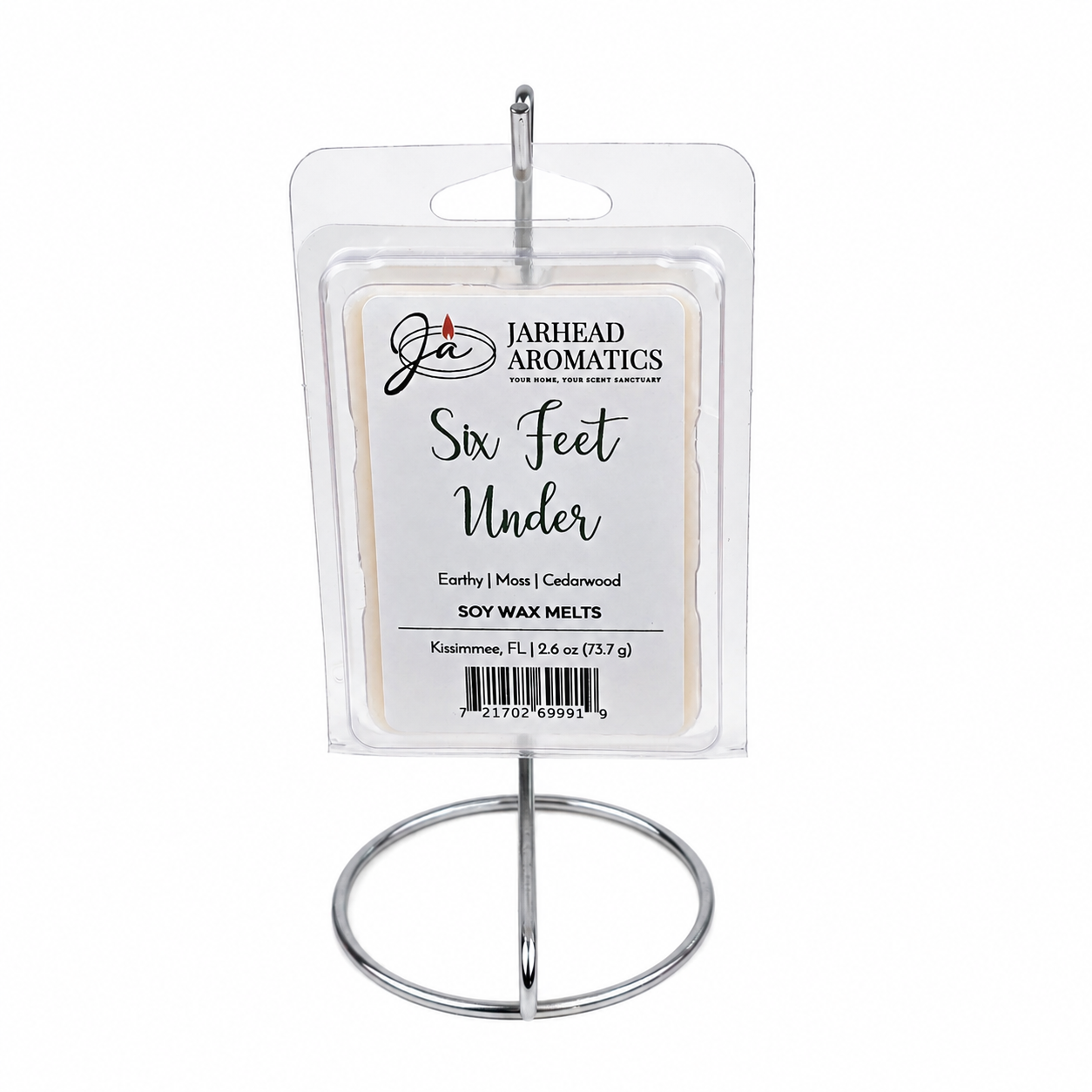 A package of Jarhead Aromatics Six Feet Under Soy Wax Melt | Damp Earth, Moss & Ancient Oak, featuring a dark atmospheric fragrance of earthy damp earth, moss, and ancient oak, displayed upright on a silver stand.