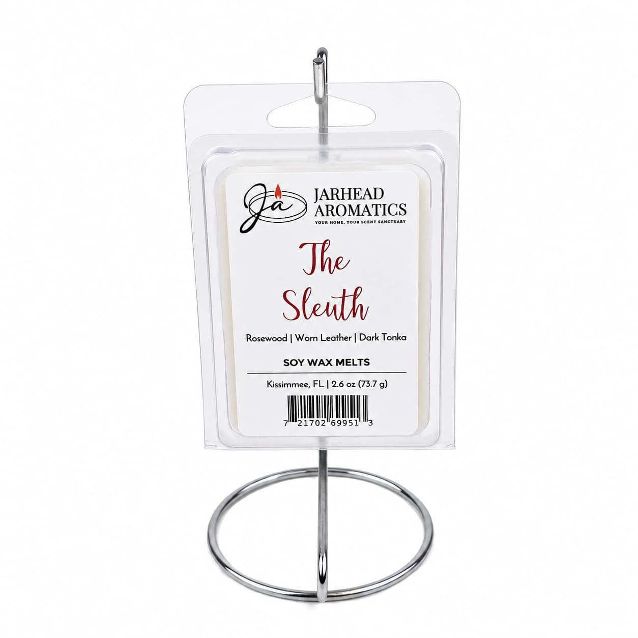 A package of Jarhead Aromatics The Sleuth Soy Wax Melt, featuring notes of leather, rosewood, and sandalwood, is displayed on a metal stand.
