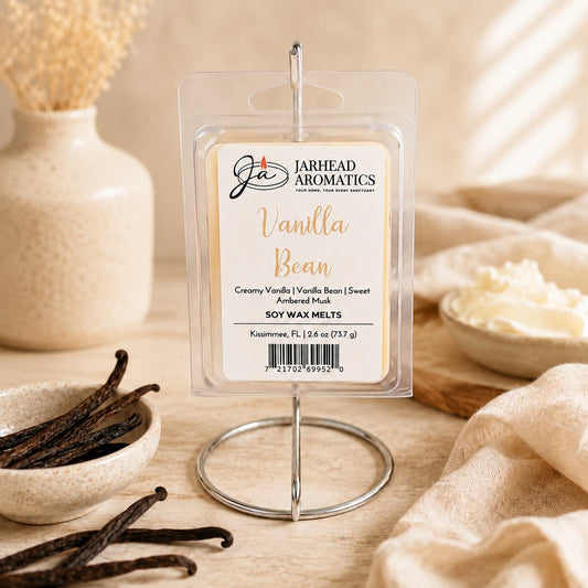 Jarhead Aromatics Vanilla Bean Soy Wax Melt | Creamy Vanilla & Amber Musk is displayed on a metal stand, surrounded by vanilla beans, a spoon, and a bowl of whipped cream on a beige surface—perfect for elevating your home fragrance with the rich aroma of creamy vanilla and amber musk soy wax melts.