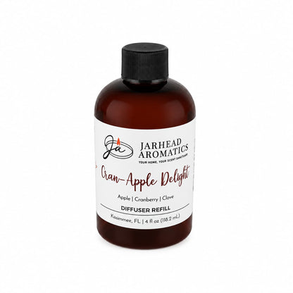 A 4oz brown bottle of Jarhead Aromatics Cran-Apple Delight Diffuser Refill—featuring cranberry, apple, and warm cinnamon notes—adds a crisp autumn aroma to your home. Made in Kissimmee, FL, it includes a black cap and white label.