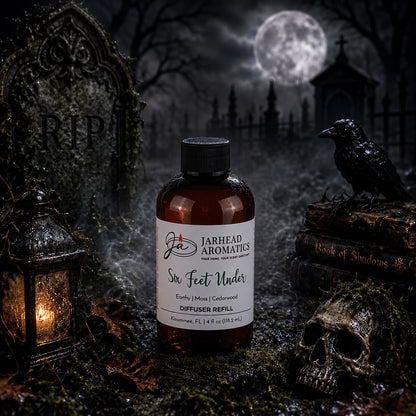 A bottle of Jarhead Aromatics’ Six Feet Under Diffuser Refill | Damp Earth, Moss & Ancient Oak, part of their atmospheric home fragrance line, rests on a mossy grave. Nearby lie a skull, crow, lantern, and book. Its earthy aroma mingles with the mist in the moonlit cemetery scene, tombstones looming in the background.