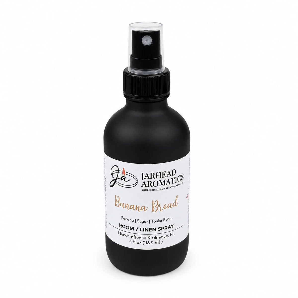 A black spray bottle labeled Jarhead Aromatics Banana Bread Room & Linen Spray features scent notes of banana, walnut, and warm vanilla. This 4 fl oz spray offers a delightful gourmand fragrance that fills your space with the comforting aroma of freshly baked treats—perfect for enhancing any home fragrance collection. Handcrafted in Kissimmee, FL.