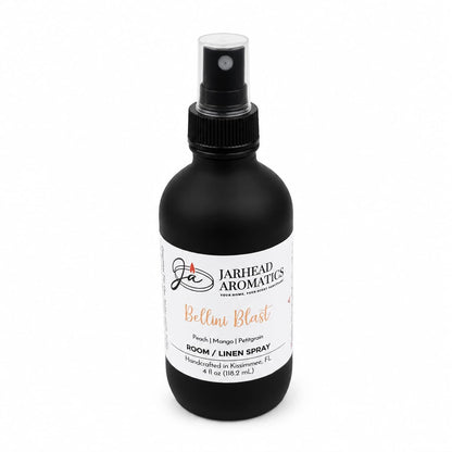 A sleek black spray bottle labeled Jarhead Aromatics Bellini Blast Room & Linen Spray offers a lively blend of peach, mango, and tangerine. This 4 oz handcrafted spray, made in Kissimmee, FL, fills any room with a tropical burst of fragrance.