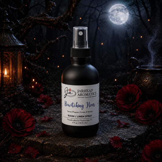 A Jarhead Aromatics Bewitching Hour Room & Linen Spray | Dark Florals, Spices & Smoky Woods bottle rests among red flowers and lanterns beneath a full moon in a mystical nightscape, evoking an enchanting home fragrance experience with this captivating room spray.