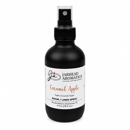 A black spray bottle labeled Jarhead Aromatics Caramel Apple Room & Linen Spray features the crisp scents of apple, caramel, and warm spice. This fall-inspired home fragrance boasts a white label and black cap for an elegant touch.