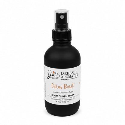 A black spray bottle labeled Jarhead Aromatics Citrus Burst Room & Linen Spray is displayed on a white background. Handcrafted in Kissimmee, FL, this 4 fl oz home fragrance features a refreshing blend of orange, mango, grapefruit, and peach scents.