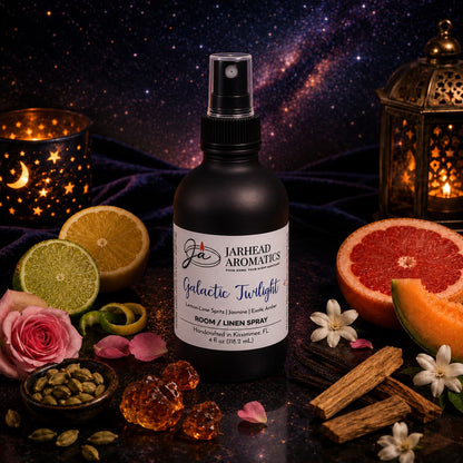 A bottle of Jarhead Aromatics Galactic Twilight Room & Linen Spray | Bergamot, Amber & Sandalwood rests amid sliced lime, grapefruit, flowers, spices, crystals, and ornate lanterns against a starry night backdrop—an inviting scene that perfectly captures the essence of this luxurious home fragrance.