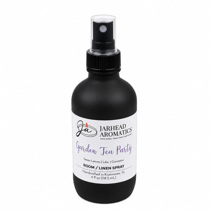 A black spray bottle labeled Jarhead Aromatics Garden Tea Party Room & Linen Spray offers a floral fragrance blend of rose, lilac, and jasmine—evoking the essence of a blooming garden. Handcrafted in Kissimmee, FL, this 4 fl oz home fragrance is perfect for refreshing any room or linen.