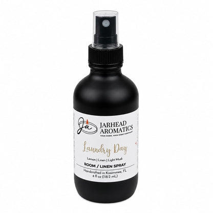 A black spray bottle labeled Jarhead Aromatics Laundry Day Room & Linen Spray features the Fresh Linen, Lemon & Clean Musk scent. Handcrafted in Kissimmee, FL, this 4-ounce (118.2 mL) bottle offers a clean home fragrance experience.