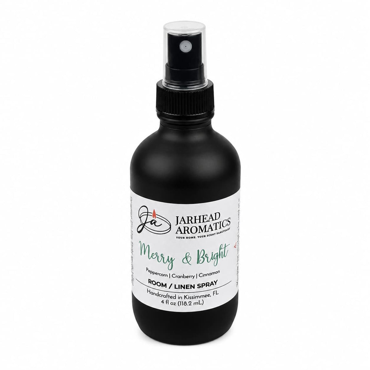 A black room and linen spray bottle with a white label featuring the Merry & Bright Room & Linen Spray | Citrus Cranberry, Warm Spice & Fir scent, notes of peppercorn, cranberry, and cinnamon, and text reading Room / Linen Spray.