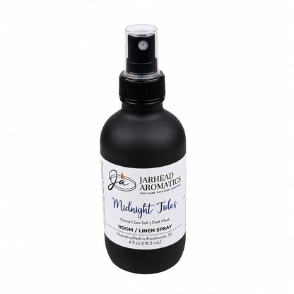 A black spray bottle with a white label and black cap, Jarhead Aromatics Midnight Tides Room & Linen Spray (4 fl oz / 118.2 ml) is hand-crafted in Kissimmee, FL. Featuring notes of sea salt, sandalwood, and dark musk, this spray infuses any room or linen with a clean coastal scent.