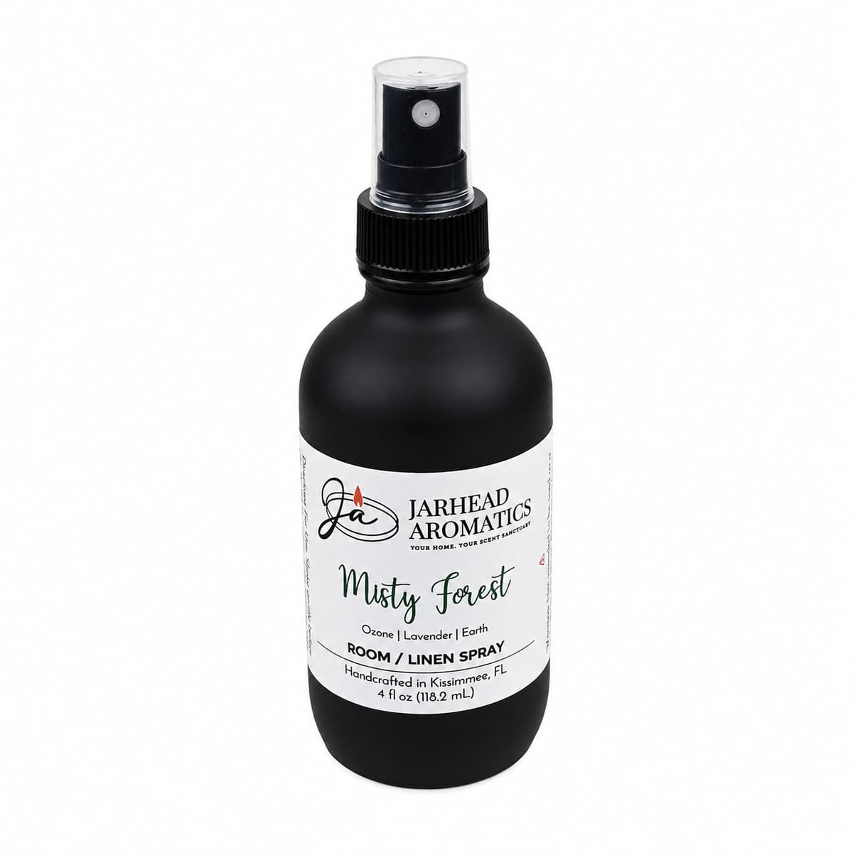A 4 oz black spray bottle labeled “Jarhead Aromatics Misty Forest Room & Linen Spray,” handcrafted in Kissimmee, FL. The label highlights notes of ozone, moss, and juniper for a woodland scent that brings a nature-inspired home fragrance to any space.