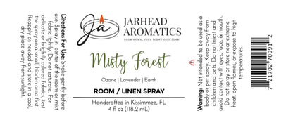 Jarhead Aromatics Misty Forest Room & Linen Spray label with usage directions and warnings, featuring a candle logo, scent notes of ozone, moss, and juniper for an authentic woodland aroma. The label emphasizes handcrafted details and the nature-inspired home fragrance experience. Black text on a white background; 4 fl oz (118.2 ml) bottle.