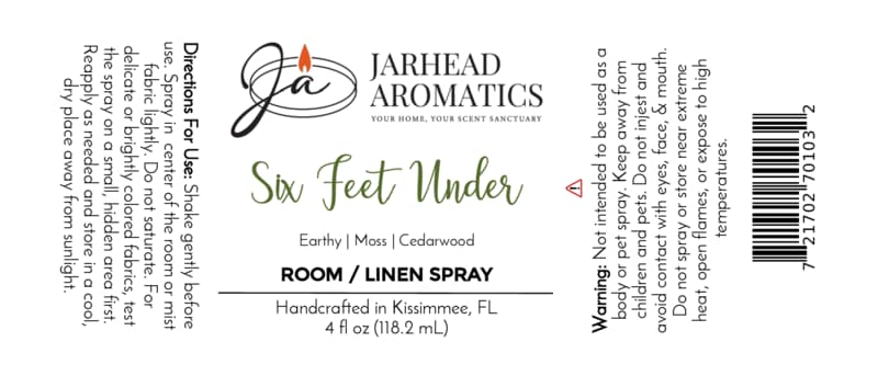 A white Jarhead Aromatics Six Feet Under Room & Linen Spray label showcases a candle logo, directions, scent notes (damp earth, moss & ancient oak), warning, barcode, and product information in black and green text—ideal for any home fragrance enthusiast.