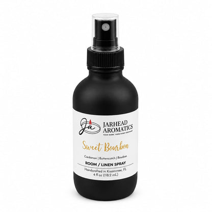 A black spray bottle labeled Jarhead Aromatics Sweet Bourbon Room & Linen Spray features notes of bourbon, butterscotch, and brown sugar. This handcrafted gourmand fragrance creates a warm, inviting atmosphere in your home. The 4 fl oz bottle is expertly made in Kissimmee, FL.