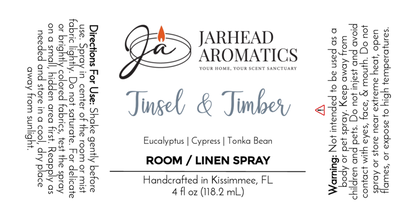 A label for Jarhead Aromatics Tinsel & Timber - Room / Linen Spray (Winter Collection), handcrafted in Kissimmee, FL with essential oils of eucalyptus, cypress, and tonka bean. Includes use directions and a warning.