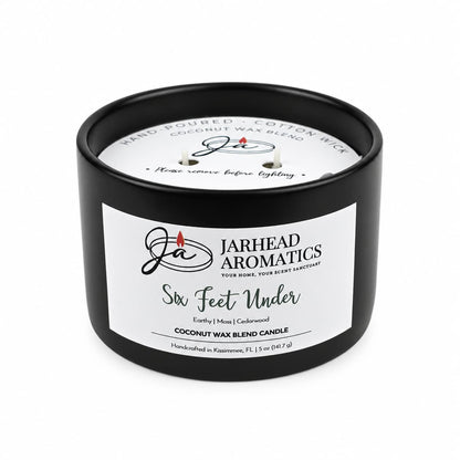 A black, cemetery-inspired Six Feet Under Coconut Wax Blend Candle by Jarhead Aromatics in a matte jar with a white label featuring the product name, scent profile, and brand details.