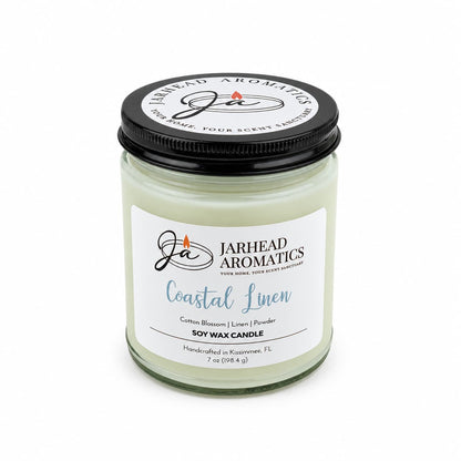 A Jarhead Aromatics Coastal Linen Soy Wax Candle in a glass jar with a black lid and a label reading Cotton Blossom, Linen & Powder.