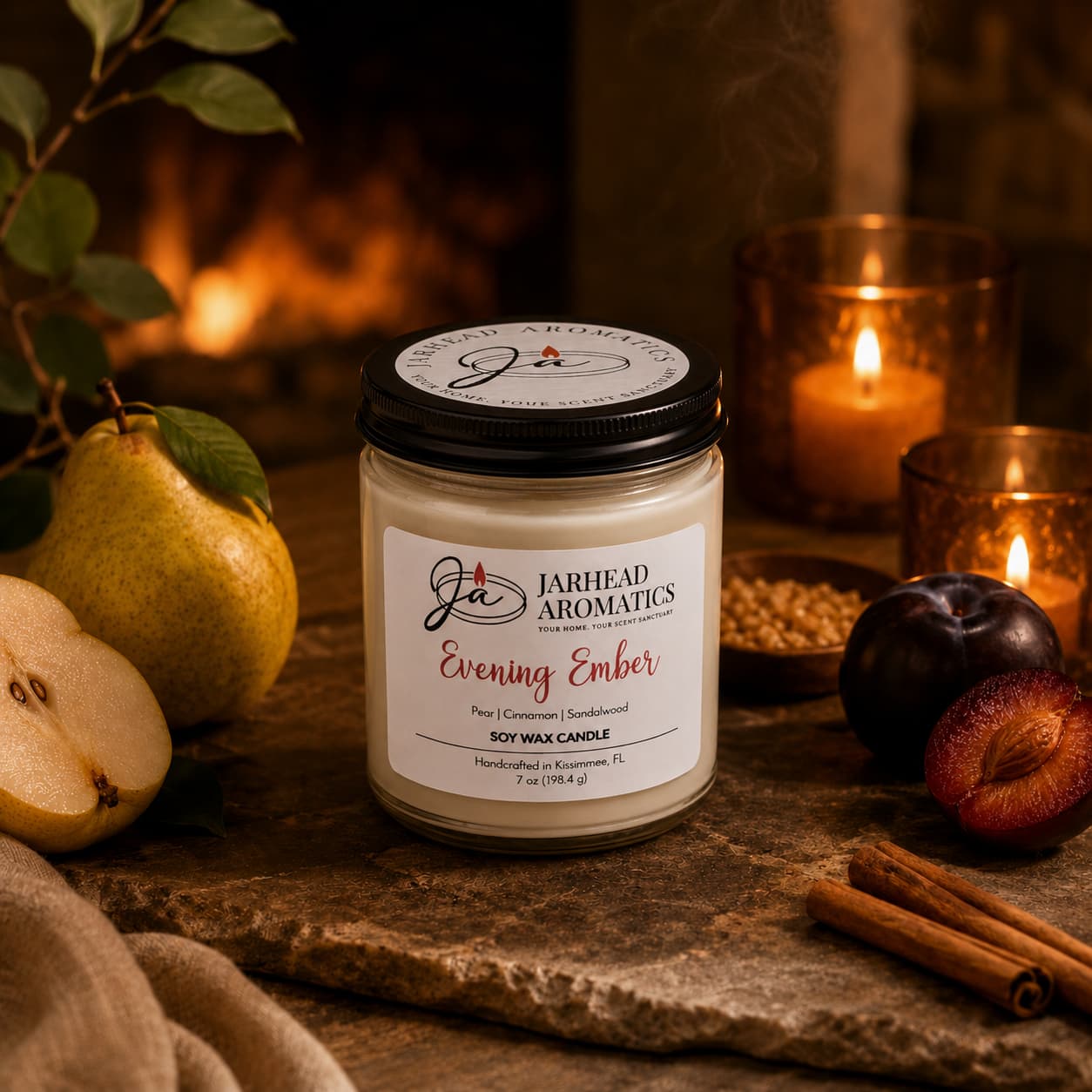 A Jarhead Aromatics Evening Ember Soy Wax Candle, scented with plum, sandalwood, and smoke, rests on a table surrounded by pears, plums, cinnamon sticks, and a glowing flame in front of a cozy fireplace.