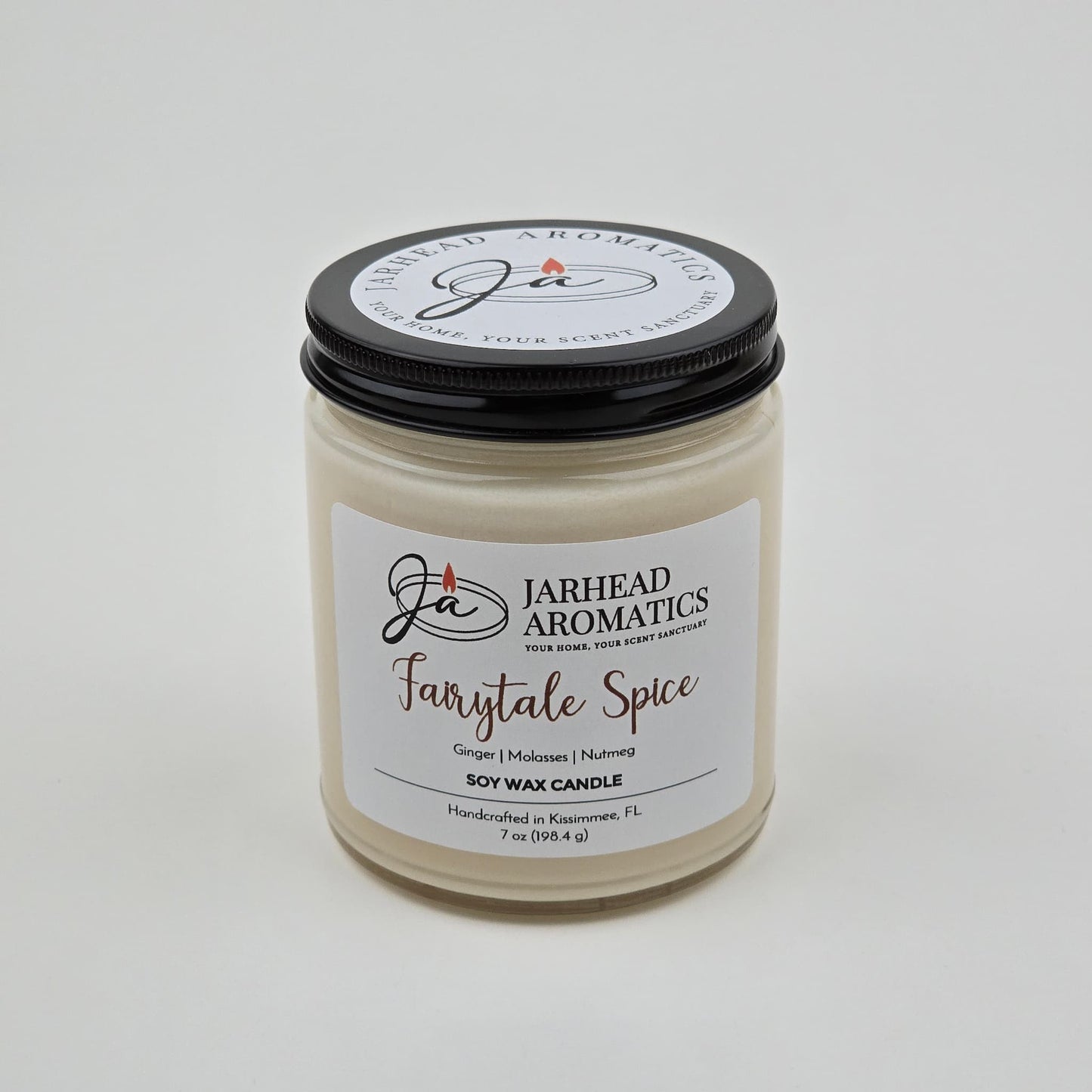 The Jarhead Aromatics Fairytale Spice Soy Wax Candle is a handcrafted holiday candle made in Kissimmee, FL. This gingerbread, cinnamon & vanilla candle comes in a glass jar with a black lid and features a white label listing its warm, cozy scents—perfect for anyone who loves the inviting aroma of a gingerbread-inspired candle.