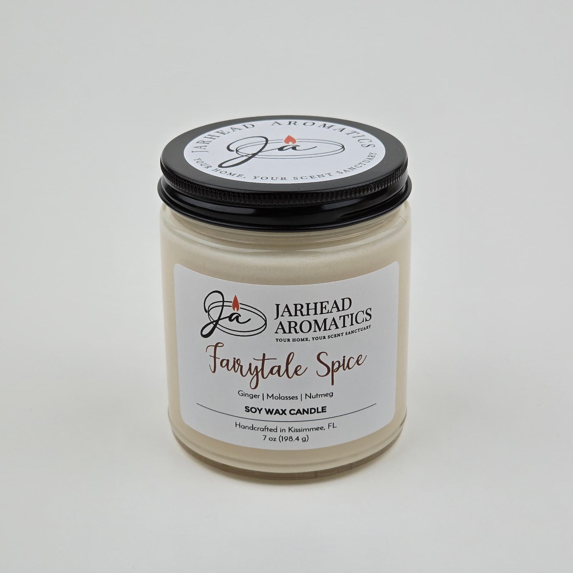 The Jarhead Aromatics Fairytale Spice Soy Wax Candle is a handcrafted holiday candle made in Kissimmee, FL. This gingerbread, cinnamon & vanilla candle comes in a glass jar with a black lid and features a white label listing its warm, cozy scents—perfect for anyone who loves the inviting aroma of a gingerbread-inspired candle.