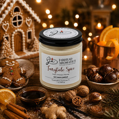 A Jarhead Aromatics Fairytale Spice Soy Wax Candle | Gingerbread, Cinnamon & Vanilla Candle rests on a wooden table surrounded by nuts, orange slices, spices, a gingerbread house, gingerbread cookies, festive lights, and a copper mug. This delightful holiday candle fills the air with warm notes of gingerbread, cinnamon, and vanilla—creating a cozy celebratory ambiance perfect for the season.