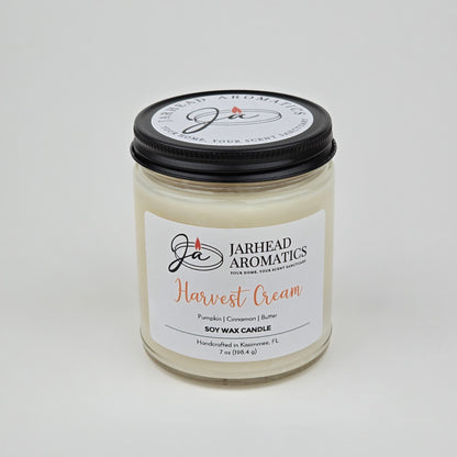 Experience the warmth of autumn with the Harvest Cream Soy Wax Candle by Jarhead Aromatics—a handcrafted 7 oz white soy wax candle in a glass jar with a black lid. Labeled “Harvest Cream,” this candle fills your space with an inviting blend of pumpkin spice, brown sugar, and vanilla. Made in Kissimmee, FL.