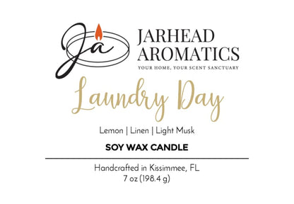 Jarhead Aromatics Laundry Day Soy Wax Candle features fresh linen, lemon, and light musk notes for a long-lasting clean scent that brightens any space. Handcrafted in Kissimmee, FL. 7 oz (198.4 g). The logo displays the brand’s initials with a flame design.