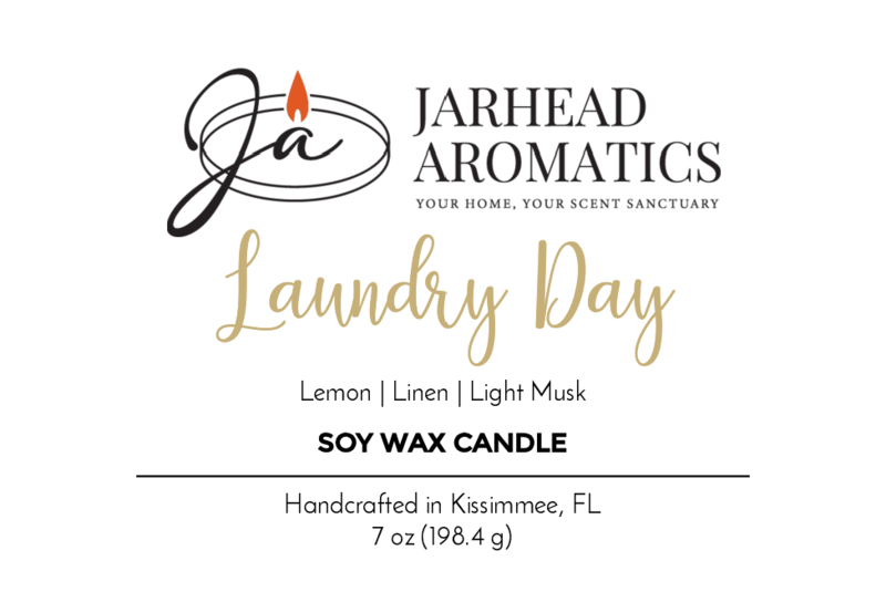 Jarhead Aromatics Laundry Day Soy Wax Candle—7 oz, handcrafted in Kissimmee, FL. Scent notes: lemon, linen, light musk. Infused with essential oils. Features a stylized “JA” with flame logo on the label.