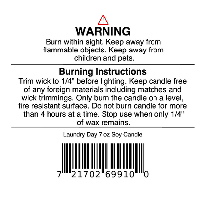 Jarhead Aromatics warning label includes safety and burning instructions, a barcode, and guidance to trim the wick, keep away from flammable objects, and avoid burning for more than 4 hours. This Fresh Linen, Lemon & Light Musk candle delivers a clean fragrance experience. The Laundry Day Soy Wax Candle | Fresh Linen, Lemon & Light Musk Candle 7 oz is noted at the bottom.