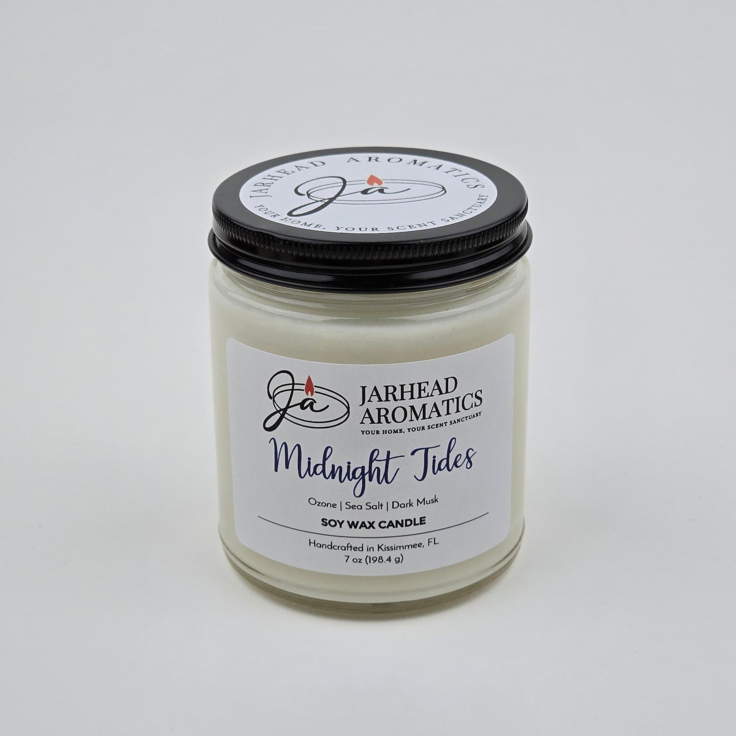 The Jarhead Aromatics Midnight Tides Soy Wax Candle, featuring an alluring blend of sea salt, dark musk, and sandalwood, is reminiscent of fresh ocean air. This handcrafted candle comes in a clear jar with a black lid and is carefully made in Kissimmee, FL.