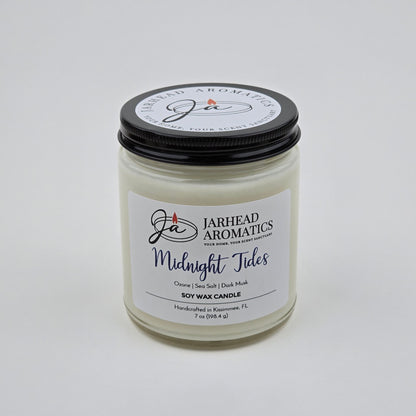 The Jarhead Aromatics Midnight Tides Soy Wax Candle, featuring an alluring blend of sea salt, dark musk, and sandalwood, is reminiscent of fresh ocean air. This handcrafted candle comes in a clear jar with a black lid and is carefully made in Kissimmee, FL.
