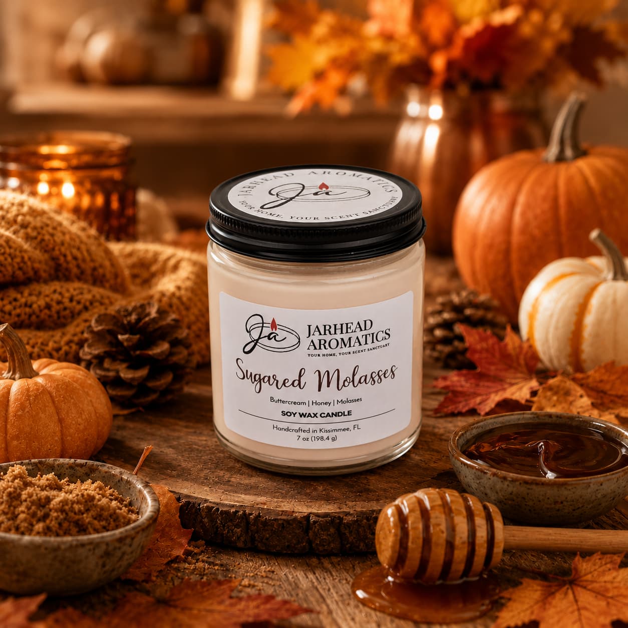 A Sugared Molasses Soy Wax Candle by Jarhead Aromatics sits on a rustic table surrounded by pumpkins, autumn leaves, a bowl of brown sugar, a honey dipper with honey, and a softly glowing candle—evoking the warmth and coziness of fall. This handmade Brown Sugar, Honey, Cinnamon & Molasses Fall Candle fills the room with a rich gourmand fragrance that perfectly captures the essence of autumn.