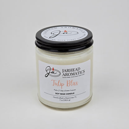 Introducing the Tulip Bliss Soy Wax Candle by Jarhead Aromatics—a handcrafted, white floral-scented candle in a glass jar. This 7 oz (198.4 g) candle features an elegant blend of peach, tulip, and soft musk notes. Made in Kissimmee, FL, each candle comes labeled with the Jarhead Aromatics brand for a touch of artisan quality.