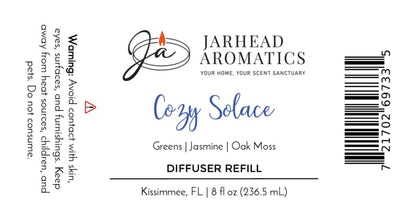 Jarhead Aromatics Cozy Solace Diffuser Refill | Fresh Greens, Jasmine, Oak Moss label featuring product details, ingredients (Fresh Greens, Jasmine, Oak Moss), barcode, and a warning to avoid contact. This autumn home fragrance offers a comforting touch for your space. Proudly crafted in Kissimmee, FL—perfect for use with your favorite home fragrance diffuser.