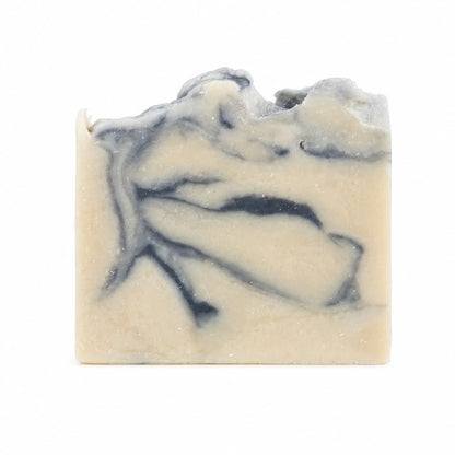 A rectangular bar of Cashmere + Santal Handmade Coconut Milk Artisan Soap by Jarhead Aromatics, showcasing a beige base with dark gray marbled swirls and an uneven top edge, displayed against a white background.