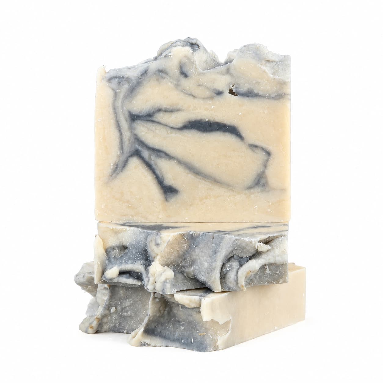 Two Cashmere + Santal Handmade Coconut Milk Artisan Soap bars by Jarhead Aromatics are stacked vertically on a white background. The top bar showcases elegant beige and gray swirling patterns, while the bottom bar displays a rougher, uneven texture—highlighting the artistry of this warm, smoky sandalwood artisan soap.