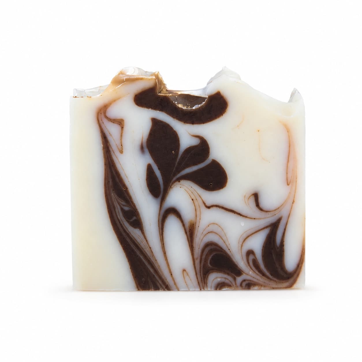 Introducing the Cedarwood + Cocoa Handmade Natural Tallow Artisan Soap by Jarhead Aromatics—a rectangular bar of soap featuring a white base adorned with intricate dark brown swirls, creating a striking marbled pattern. Its uneven top edge showcases the distinct handmade character typical of natural artisan soaps. Enjoy the warm aroma of cedarwood paired with earthy cocoa in every luxurious lather.
