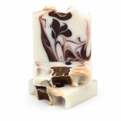 Three rectangular bars of Jarhead Aromatics Cedarwood + Cocoa Handmade Natural Tallow Artisan Soap are stacked on top of each other against a white background. The top bar, from the Warm Cedarwood & Earthy Cocoa collection, features decorative marbled brown and black patterns that highlight its artisan craftsmanship.