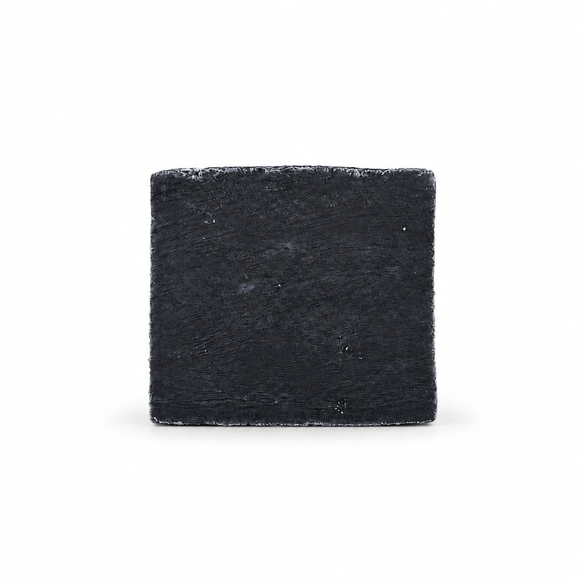 A square, black Jarhead Aromatics Charcoal Natural Handmade Soap bar with a textured surface.